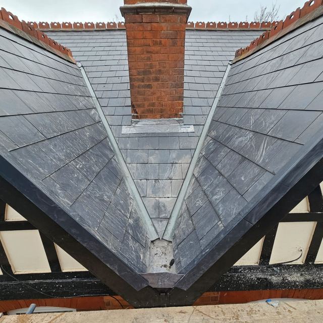 Slate roof valleys meeting at a chimney