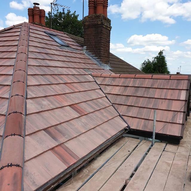 New red tiled roof with a hip and a roof window