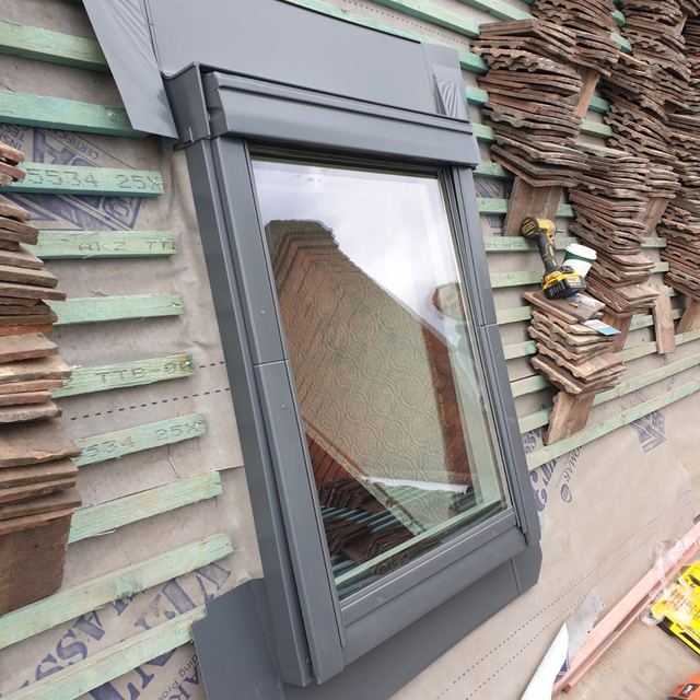 New roof window being fitted into a tiled roof