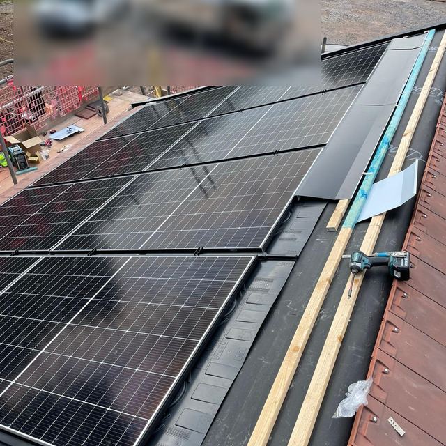 Solar panels being fitted into a new roof